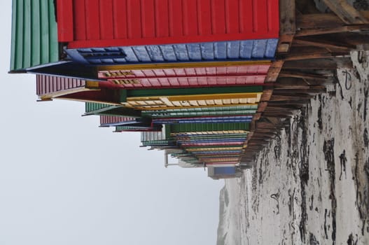 Backview of colorful beach houses in south africa on a foggy day