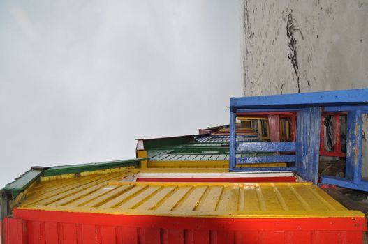 Colourful beachhouses at the beach on a foggy day