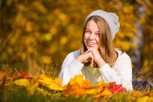 Portrait of pretty nice teenage girl with dental braces in autumn park , background with copy space for text, autumn special offer sale concept