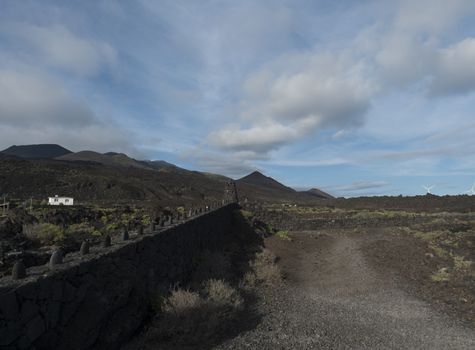 Volcanic landscape at Fuencaliente salinas near Los Canarios with lava rock wall. La Palma, Canary Islands, blue sky white clouds