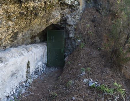 Closed iron doors to the tunnel at danger hiking trail Barranco de la Madera from Las Nieves, La Palma Island, Canary Islands, Spain.