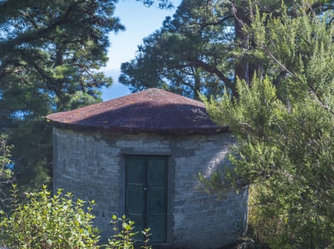 Rounded stone house for water duct levada maintenance at hiking trail Barranco de la Madera from Las Nieves, La Palma Island, Canary Islands, Spain.