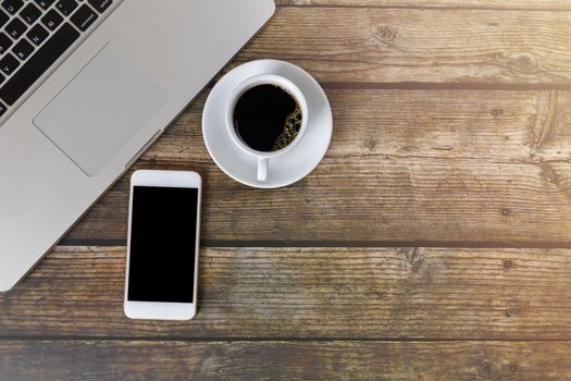 Laptop, smartphone coffee on wood table. Laptop, mobile phone, black coffee on table with copy space banner. Business concept.
