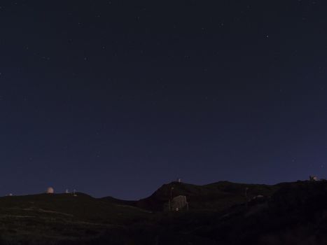 Night astrophotography, sky with stars at Roque de los Muchachos with telescopes of astronomical observatory, la Palma, Canary islands, Spain.