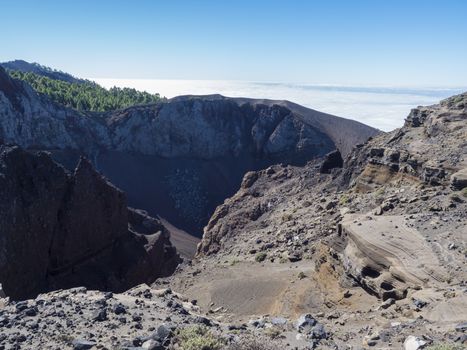 View to crater of volcano El Duraznero along the path Ruta de los Volcanes, beautiful hiking trail at La Palma island, Canary Islands, Spain, Blue sky background.