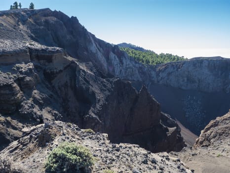 View to crater of volcano El Duraznero along the path Ruta de los Volcanes, beautiful hiking trail at La Palma island, Canary Islands, Spain, Blue sky background.