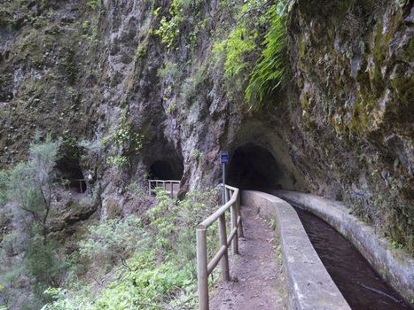 Water duct levada and mysterious tunnel on hiking trail Casa del Monte to Los Tilos. Beautiful nature reserve on La Palma, Canary islands, Spain.