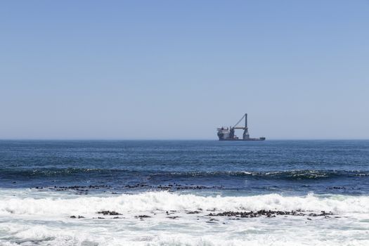 Ship very far away in the ocean on the Sea Point promenade in South Africa's Cape Town.