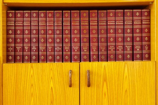 Haifa, Israel = August 14, 2019: Volumes 1 - 17 of the Encyclopedia Britannica, 1965 edition, on a wooden bookshelf