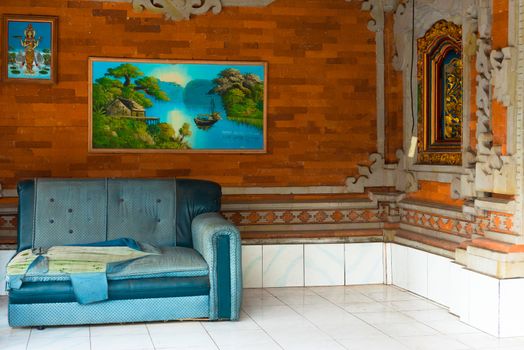 Torn couch and wall paintings in outdoor living space. editorial use only