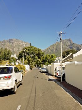 Street in the town of Claremont, Cape Town, South Africa. Sunny weather and panorama of Table Mountains.