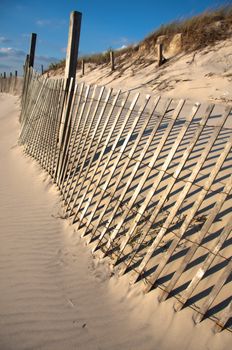 Fence Sandy beach. Cloudy sky.