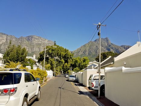 Street in the town of Claremont, Cape Town, South Africa. Sunny weather and panorama of Table Mountains.