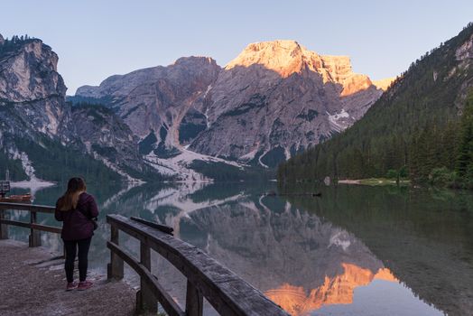 A person looks out over Lake Braies, image of tourism scene in Italy