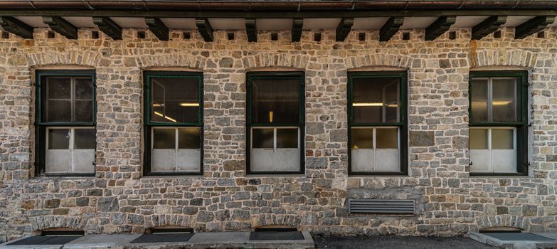 Series of windows lined up on a building of clear stones, mountain architecture