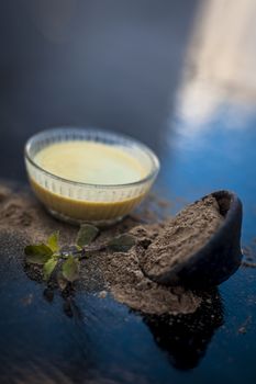 Ayurvedic herb brahmi or Waterhyssop with its beneficial paste ina glass bowl along with its powder on wooden surface.