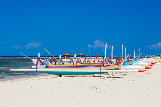 Beach scene and traditional Balinese boat on a Sanur beach in Bali, Indonesia