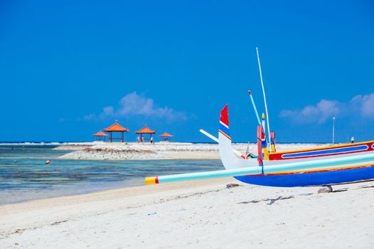 Beach scene and traditional Balinese boat on a Sanur beach in Bali, Indonesia