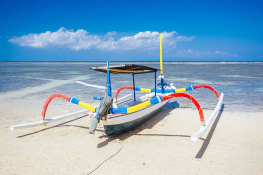 Beach scene and traditional Balinese boat on a Sanur beach in Bali, Indonesia