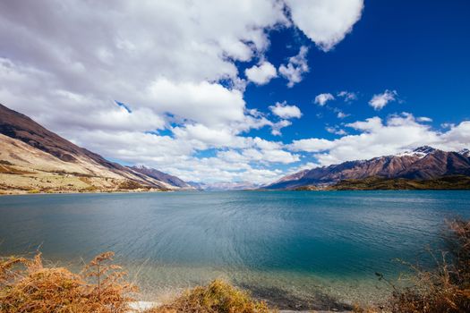 Lake Wakatipu and surrounding mountains from Twenty Five Mile Stream campground, on a sunny spring day near Glenorchy in New Zealand