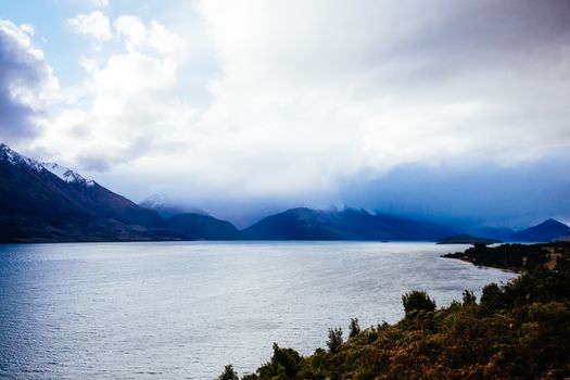 Lake Wakatipu and surrounding mountains, including Tooth Peaks from near Bennetts Bluff Lookout, on a sunny spring day approaching sunset near Glenorchy in New Zealand