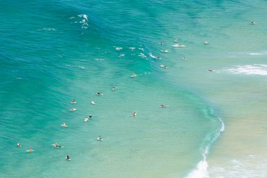 An aerial view of surfers at Tallows Beach in Byron Bay, New South Wales, Australia