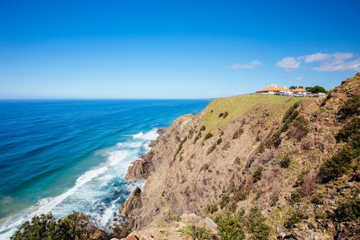 The iconic and famous Byron Bay lighthouse and rocky seascape on a hot autumn day in Byron Bay, New South Wales, Australia.