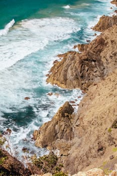 The iconic and famous Byron Bay lighthouse and rocky seascape on a hot autumn day in Byron Bay, New South Wales, Australia.