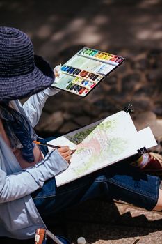 Kyoto, Japan - May 17 2019: A beautiful older Japanese lady paints at Nanzen-ji Temple in Kyoto on a warm spring day in Japan