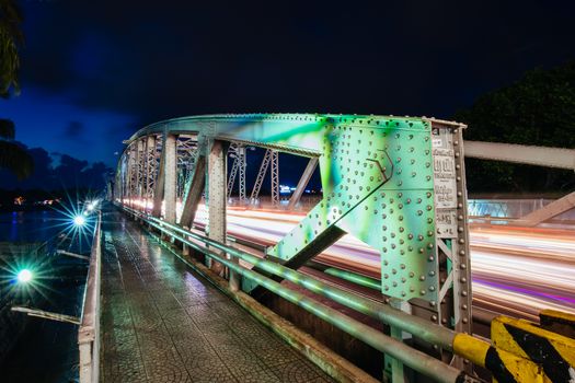 The iconic Truong Tien Bridge in Hue Vietnam at rush hour with lots of traffic on a warm and wet evening