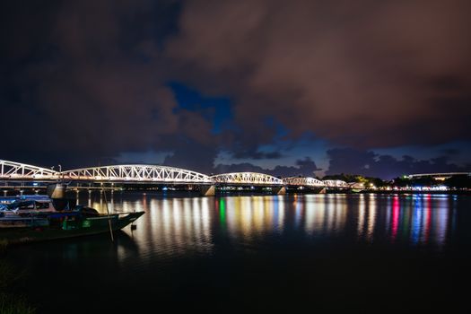 The iconic Truong Tien Bridge in Hue Vietnam at rush hour with lots of traffic on a warm and wet evening