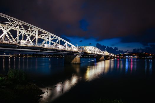 The iconic Truong Tien Bridge in Hue Vietnam at rush hour with lots of traffic on a warm and wet evening
