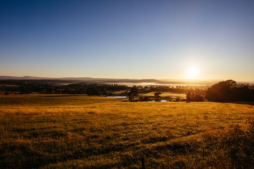 The sun rises at Kangaroo Ground towards Panton Hill on a misty autum morning in Victoria, Australia