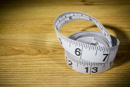 White tailor meter on a wooden table