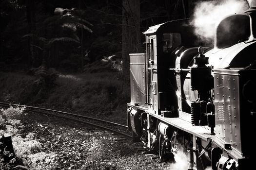 Melbourne, Australia - June 11 2012: Puffing Billy steam train travels across an old wooden bridge in Melbourne, Victoria, Australia