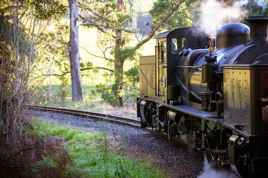 Melbourne, Australia - June 11 2012: Puffing Billy steam train travels across an old wooden bridge in Melbourne, Victoria, Australia