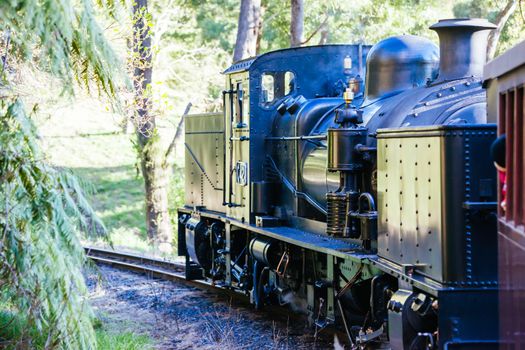 Melbourne, Australia - June 11 2012: Puffing Billy steam train travels across an old wooden bridge in Melbourne, Victoria, Australia