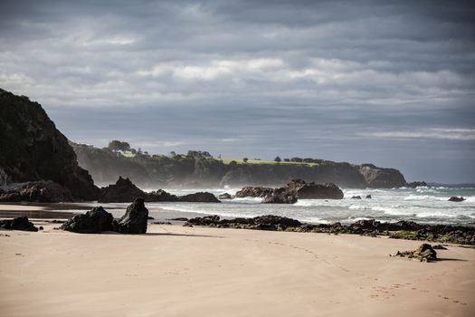 View towards Narooma Golf Course from Glasshouse Rocks Beach on a stormy day in New South Wales, Australia