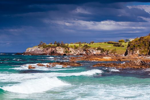 View towards Narooma Golf Course and Glasshouse Rocks Beach on a stormy day in New South Wales, Australia