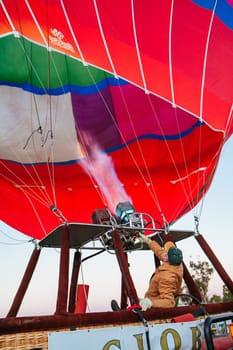 Healesville, Australia - July 24 2009: A man controls gas and flame, filling a hot air balloon with warm air on a cold winter's morning in Yarra Valley, Victoria, Australia