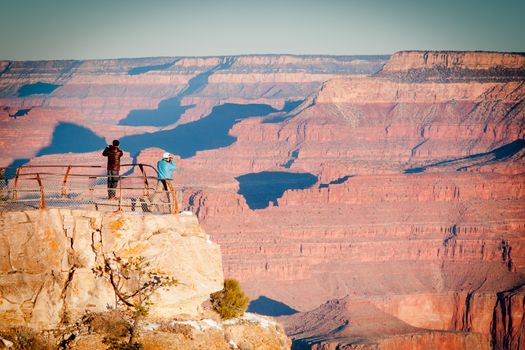 Tourists enjoy the sunrise views in winter at the South Rim in Grand Canyon, Arizona, USA