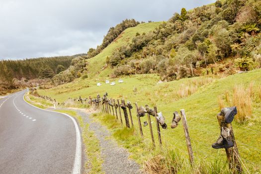 Tramping boots are laid out on a fence along Te Anga Rd near Waitomo in New Zealand