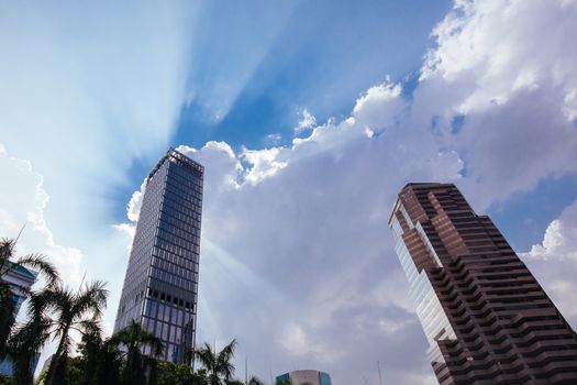 A skyscraper in Kuala Lumpur stands tall in front of a cloudy silver lining in Kuala Lumpur, Malaysia