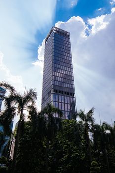 A skyscraper in Kuala Lumpur stands tall in front of a cloudy silver lining in Kuala Lumpur, Malaysia