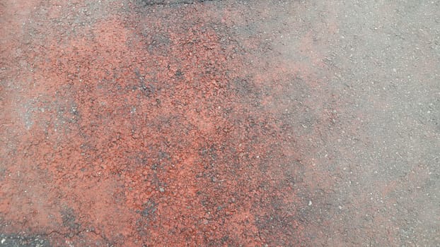 Red colored damaged road or paved pathway with crackes of different shpaes. Cracked texture with copy space for text and messages