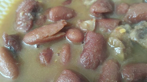 Kidney beans dish:  Closeup view of cooked red kidney beans dish. Dark red useful beans dish background.