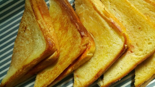 Closeup view of freshly prepared half fried slices of toast bread. Food background for bakery products