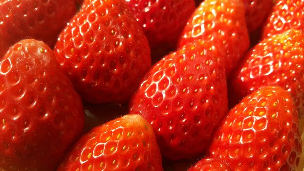 Close up macro view of healthy, fresh organic strawberries in supermarket for sale, pile of strawberries