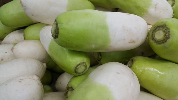 Vegetable background: Large radish (Raphanus raphanistrum) pile in supermarket. It is full of vitamins, minerals, fiber and antioxidants.