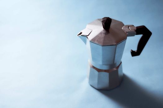 The geyser coffee maker stands on a blue background. . High quality photo